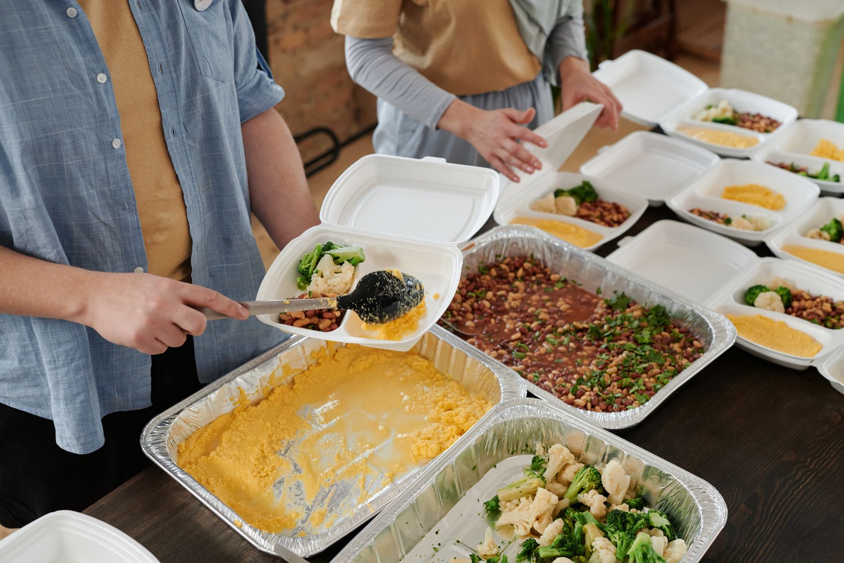 Volunteers serving prepared meals to the community at a nonprofit fundraiser