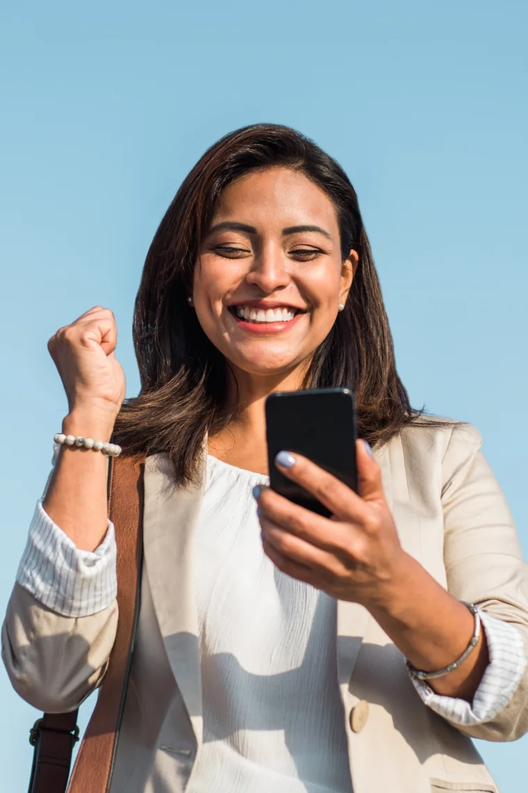 A supporter smiles at her phone outdoors while the cash prize on her RallyUp Campaign page grows